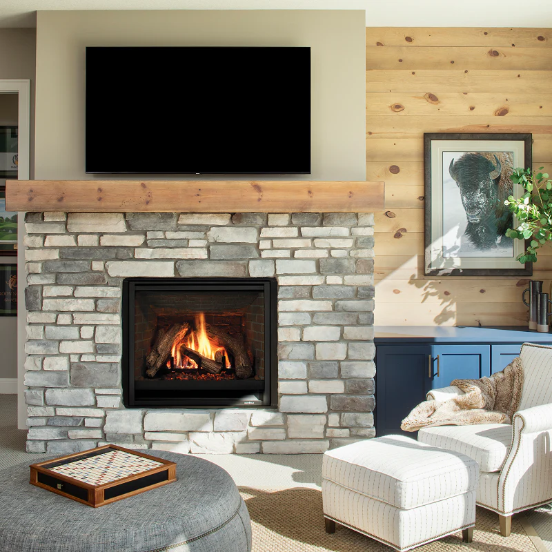 gas fireplace with stone and wood mantel near blue cabinets with bison photo on wall