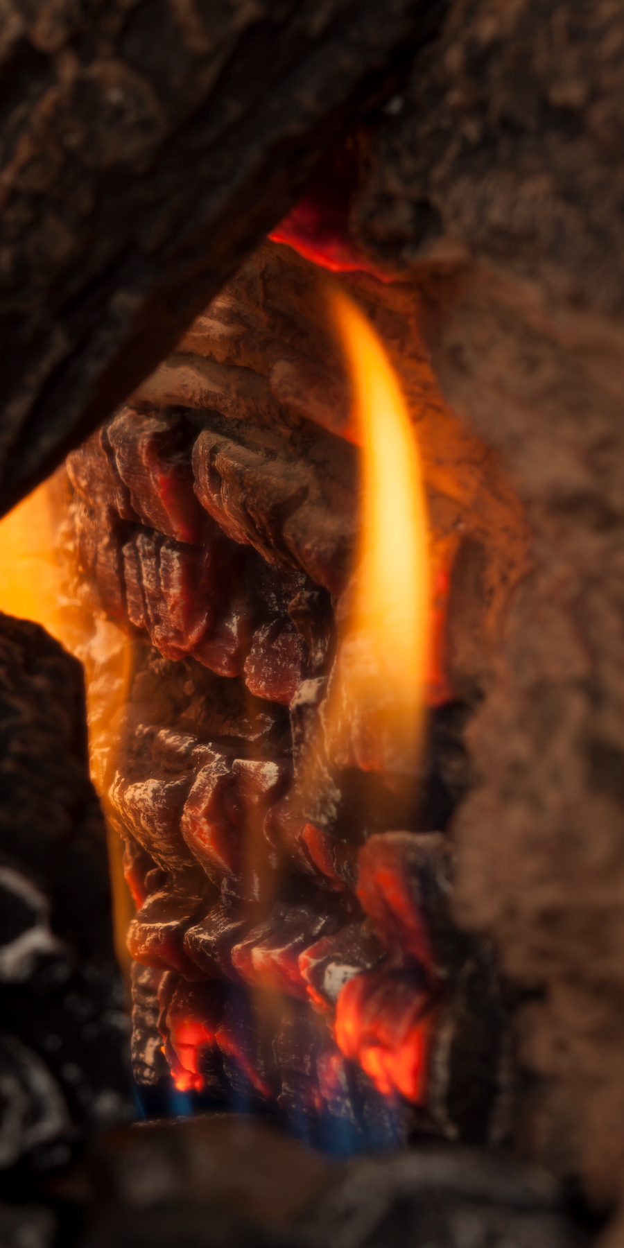 gas fireplace with timber logs and flame and burning glowing embers