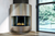 curved glass fireplace in corner with glazed surround finish