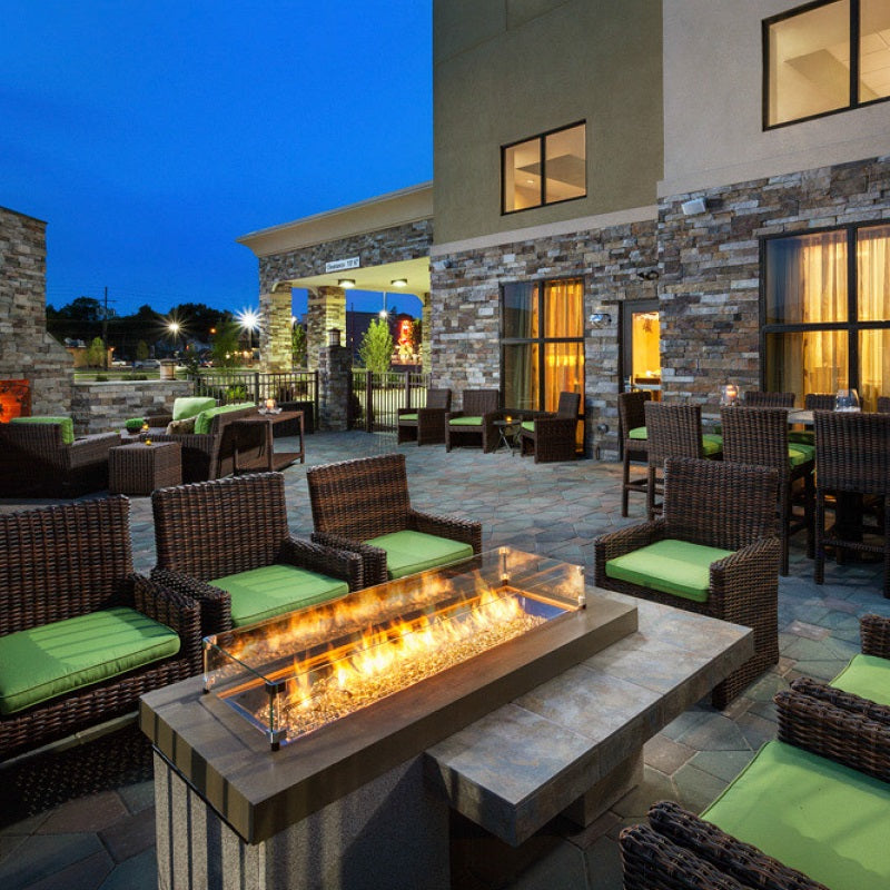 gas fire pit table in hotel courtyard with chairs and tables